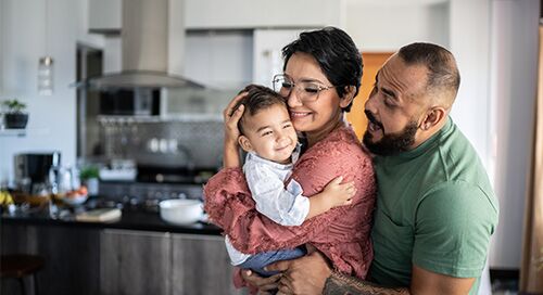 Man and woman holding a baby and smiling