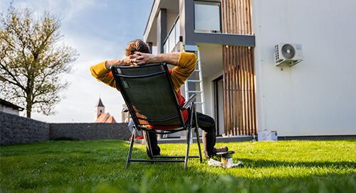 Man reclining in lawn chair in front of his condo