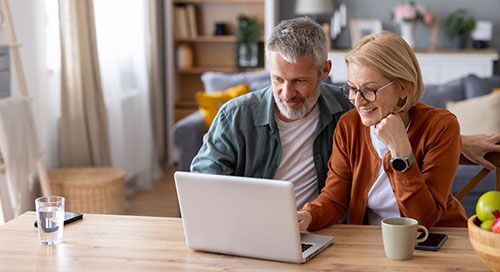 Older man and woman sitting together at a laptop