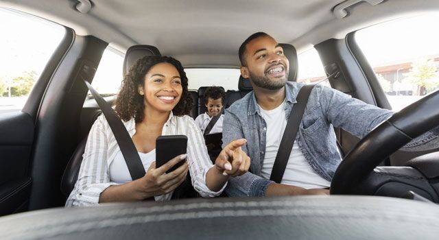 Young couple with their son driving