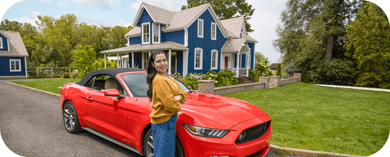 Woman in a yellow shirt standing in front of a red Mustang convertible