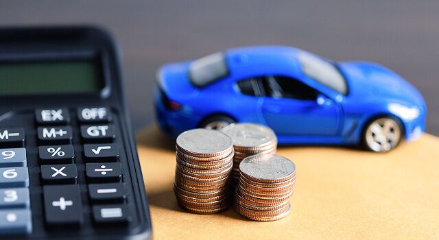 A close up photo of a calculator, a blue toy car and three stacks of quarters